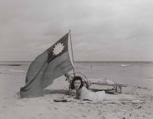 1941年12月15日，珍珠港事件后一周，迈阿密海滩，中餐馆的女服务员露丝·李在晒太阳时背后插上一面自制的中国国旗，避免被误认为日本人 source1941年12月15日，珍珠港事件后一周，迈阿密海滩，中餐馆的女服务员露丝·李在晒太阳时背后插上一面自制的中国国旗，避免被误认为日本人 source